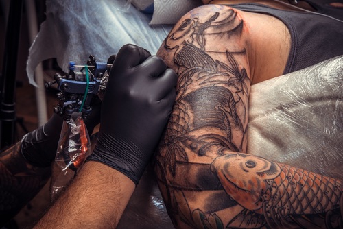 Tattoo artist doing tattoo in tattoo salon